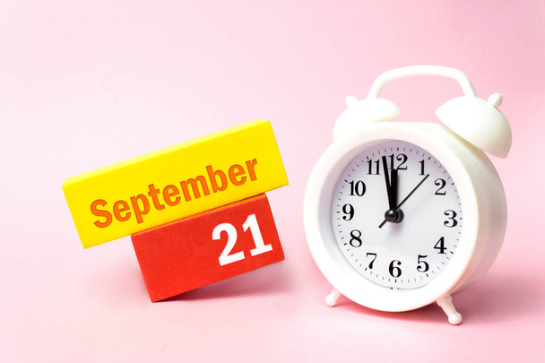 21. září. 21. den v měsíci, kalendářní den. Bílý budík na pastelově růžové pozadí. Podzimní měsíc, den koncepce roku - Fotografie, Obrázek