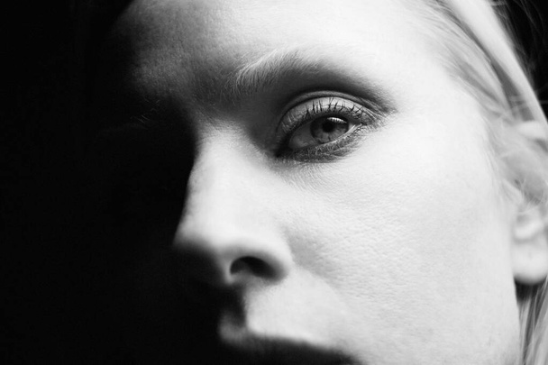 Black and white close-up portrait of young woman, posing at studio. - Valokuva, kuva