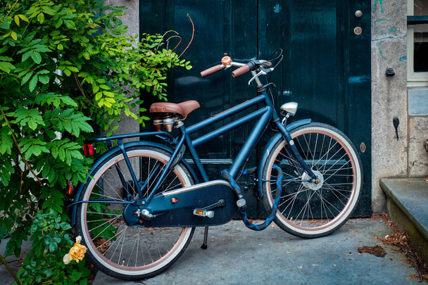 Велосипед возле двери старого дома на улице Амстердам - Фото, изображение