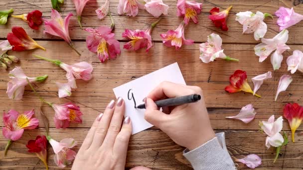 Írás jó reggel egy kártyára közel virágok tetejére nézet  - Felvétel, videó