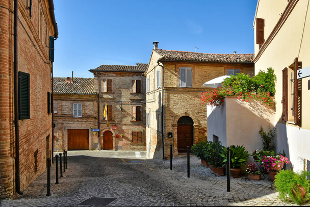Egy szűk utca a régi házak között Montecosaro, egy középkori város a Marche régió Olaszország. - Fotó, kép