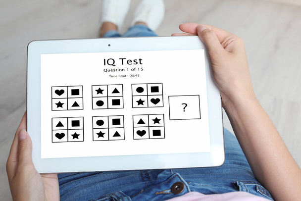 Woman using tablet for taking IQ test indoors, closeup - Zdjęcie, obraz