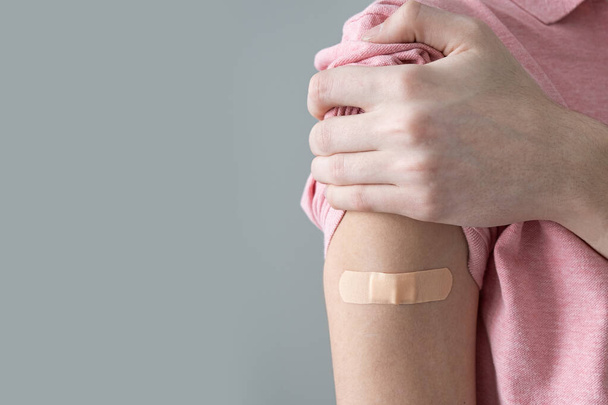 Pflaster am Arm nach Impfung gegen SOVID-19-Infektion. Impfung gegen Coronaviren. - Foto, Bild
