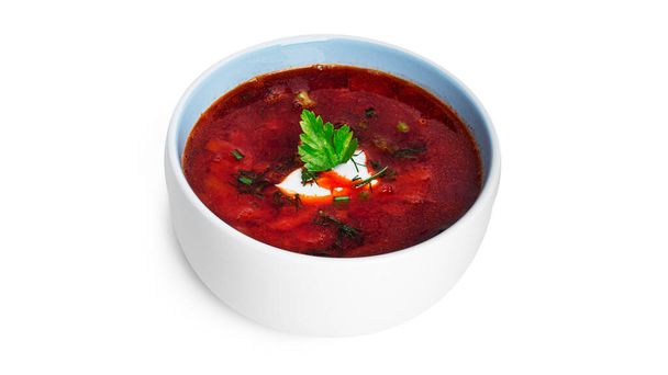 Borscht rojo y caliente: sopa de remolacha con crema agria y hierbas aisladas sobre un fondo blanco. - Foto, Imagen