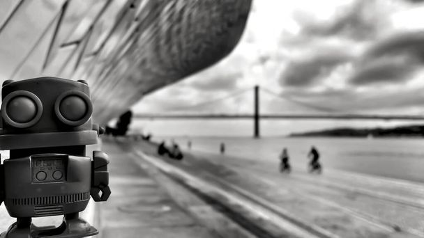 Toy robot on the banks of the Tagus River in Lisbon in a Cloudy day - Photo, Image