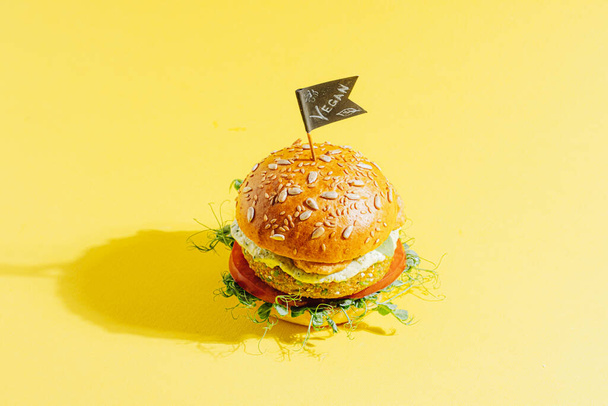 bright fresh veggie burger without gluten and meat. burger on yellow background - Fotografie, Obrázek