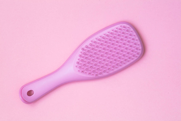 Pink hairbrush isolated on pink background - Фото, изображение