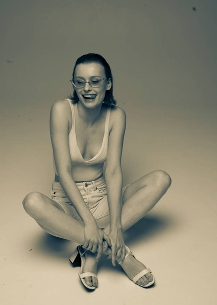 hermosa pelirroja chica sentada en el suelo en una pose de moda - Foto, Imagen