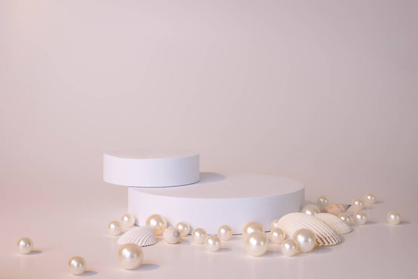 真珠と貝殻で白い背景に白い表彰台。製品のための表彰台、化粧品プレゼンテーション。創造的なモックアップ。美容製品のための台座またはプラットフォーム. - 写真・画像
