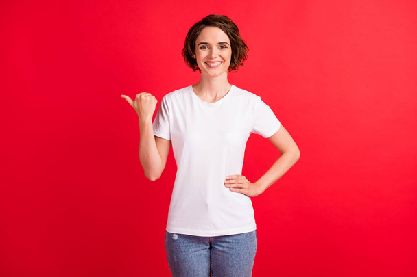 Portrait of attractive cheerful girl demonstrating copy empty space look idea follow ad isolated over bright red color background - Photo, image