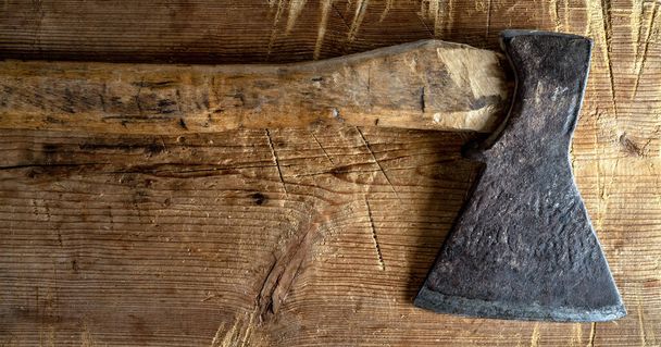 Old axe with a wooden haft on a background of rough wood texture. - Photo, Image