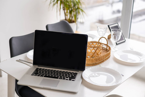 Moderner und stilvoller Laptop auf einem Tisch in der Küche - Foto, Bild