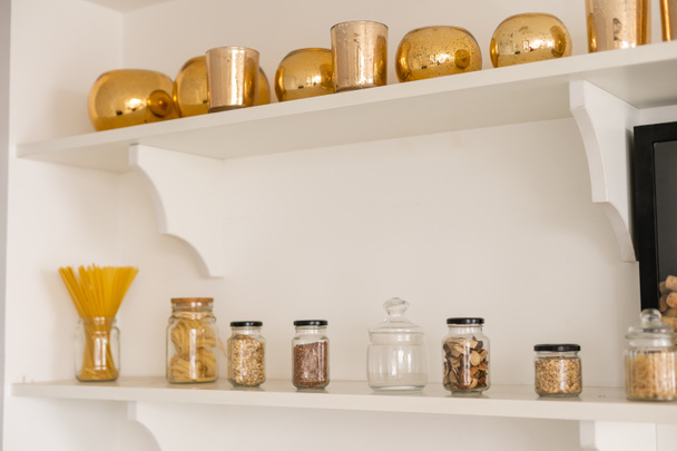 stocked kitchen pantry with food, jars and containers of cereals, jam, coffee, sugar, flour, oil, vinegar, rice - Photo, Image