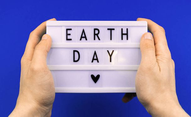 Environment concept, earth day holiday celebreation background, with text message, man hold lightbox with lettering - Photo, Image