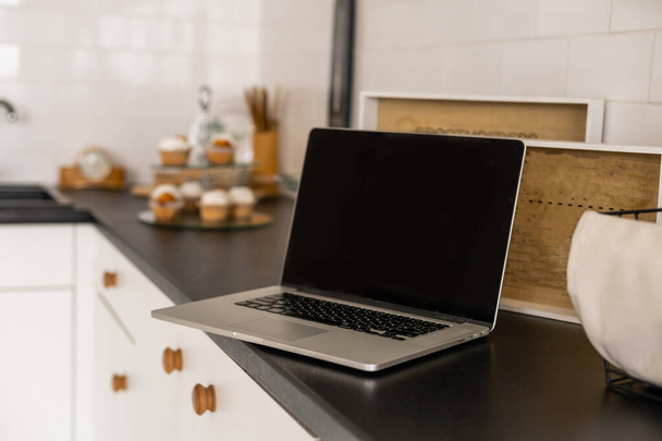 Moderni ja tyylikäs kannettava tietokone pöydällä keittiössä - Valokuva, kuva