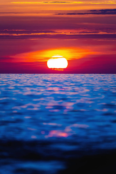 Barevný západ slunce s velkým jasným sluncem pod hladinou moře. Západ slunce, východ slunce, přímořská pláň. - Fotografie, Obrázek