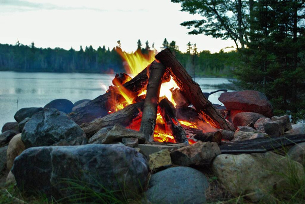 ognisko obozowe płonące w palenisku nad jeziorem - Zdjęcie, obraz