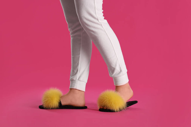 Woman in fluffy slippers on pink background, closeup - Foto, imagen