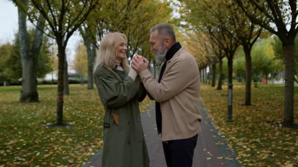 秋の公園で女の優しい手にキスするハンサムな髭の男。ロマンチックなカップル - 映像、動画