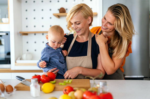 Happy lesbian female couple with her little child at home. Family, kid, fun concept - Fotoğraf, Görsel