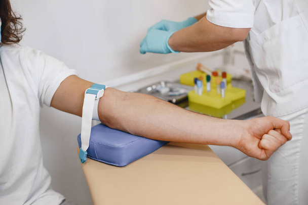 Enfermeira recolhendo amostra de sangue do paciente no consultório médico - Foto, Imagem