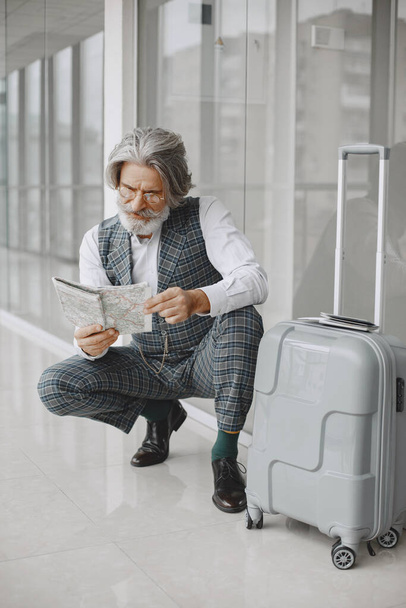 Senior businessman with travel suitcase in airport - Fotoğraf, Görsel