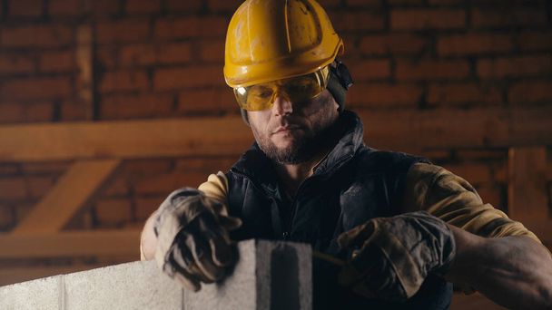 Male builder measuring brick wall - Photo, Image