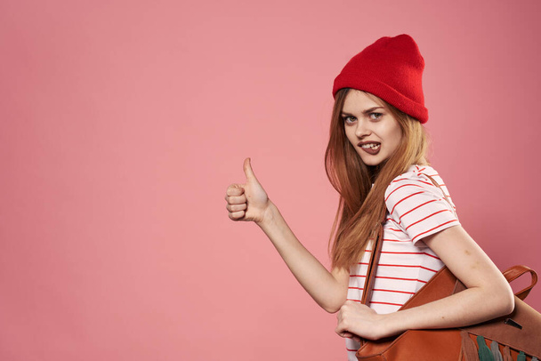 Όμορφη γυναίκα σε κόκκινο καπέλο φωτογραφία συναισθήματα χαρά ροζ φόντο - Φωτογραφία, εικόνα