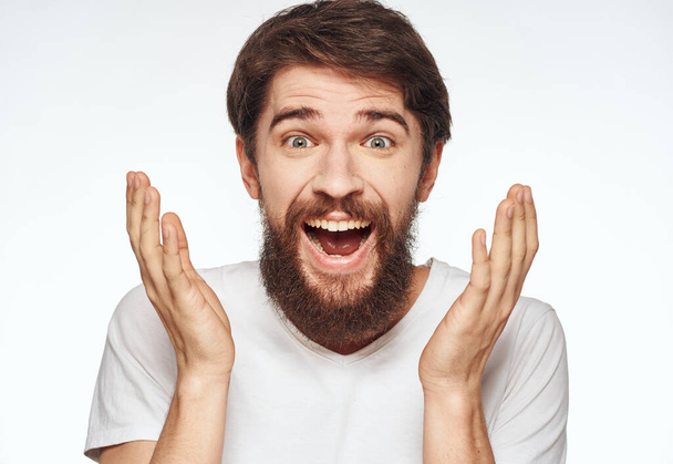 Мужчина брюнет эмоции модель светлый фон белая футболка - Фото, изображение