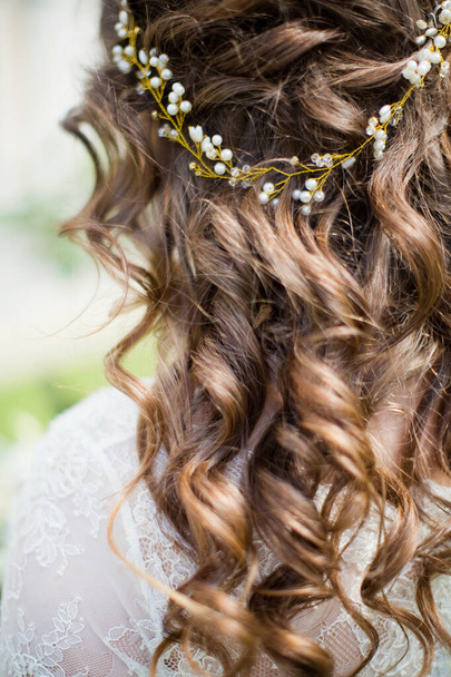 Mariée bouclée avec belle coiffure et accessoires en or dans les cheveux en plein air - Photo, image