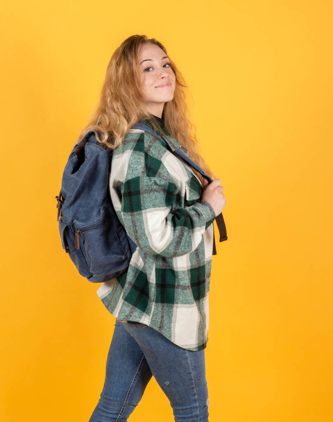 Sırt çantalı güzel sarışın kadın, sarı arka plan seyahati kavramı - Fotoğraf, Görsel