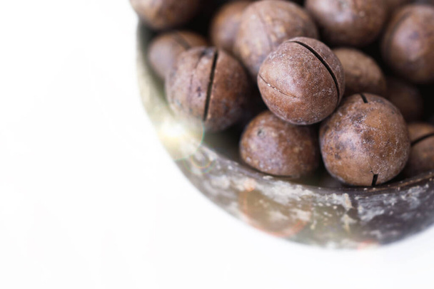 Le noci di macadamia chiudono. Macadamia in guscio in una piastra marrone - Foto, immagini