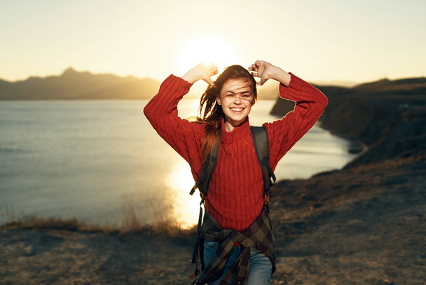 емоційна жінка турист з піднятими руками на заході сонця на горизонті природи
 - Фото, зображення