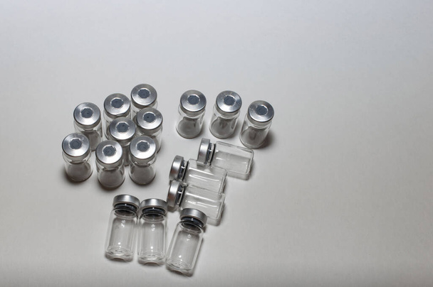 Medical empty ampoules after injections during vaccination and prevention during a pandemic on a white background close-up. blurred focus - Фото, изображение