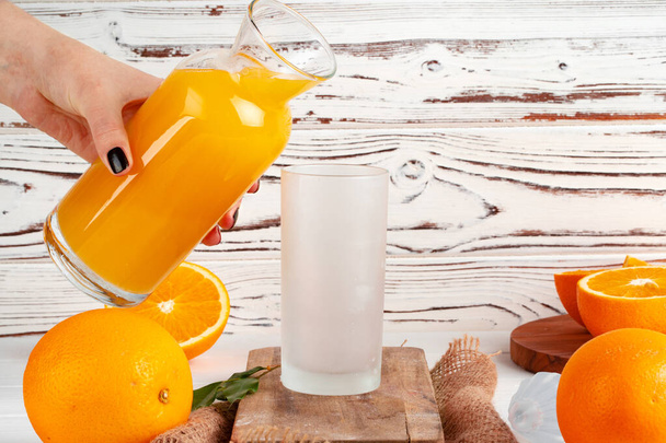 Orange juice pouring from the bottle into the glass - Valokuva, kuva