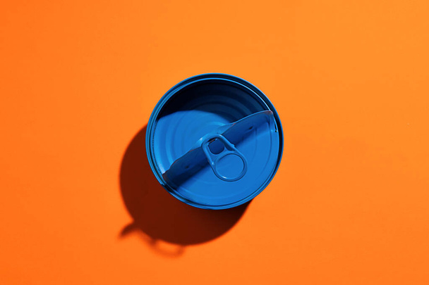 Aesthetic concept with blue painted tin can on orange background - Φωτογραφία, εικόνα