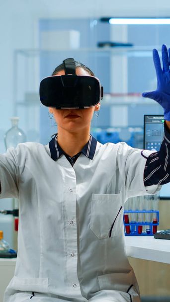 Профессиональный ученый в очках виртуальной реальности с использованием медицинской иновации в лаборатории - Фото, изображение