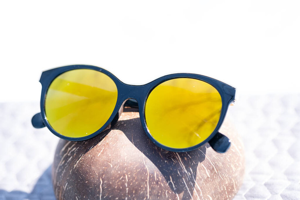 Модные солнцезащитные очки для глаз кошки для дам с большими круглыми желтыми линзами и черной оправой снимаются на улице в солнечный день. Селективный фокус  - Фото, изображение