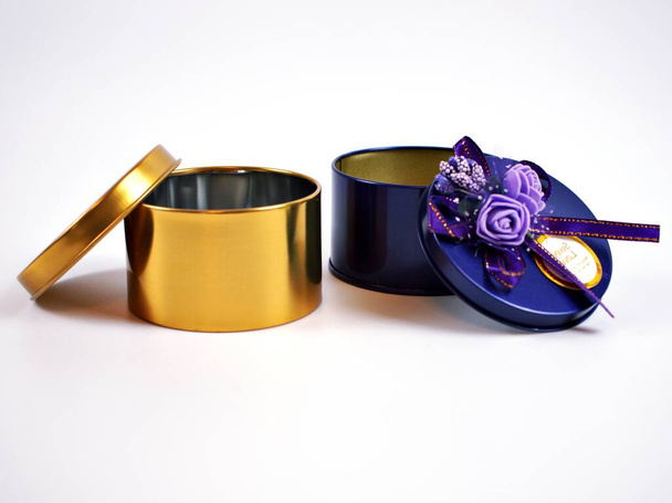 Κουτί δώρου μεταλλικό ανοιχτό άδειο χρυσό και βιολετί χρώμα με κορδέλα απομονωμένη σε λευκό φόντο - Φωτογραφία, εικόνα