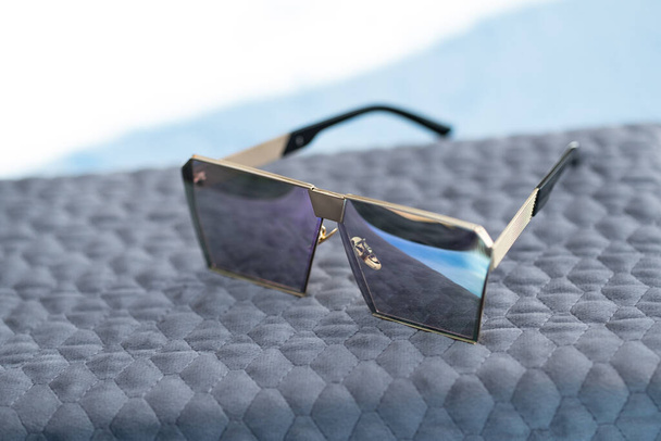 Zróżnicowany model okularów przeciwsłonecznych z różowymi płaskimi soczewkami kręci się na zewnątrz w słoneczny dzień zbliżenia. Skupienie selektywne - Zdjęcie, obraz