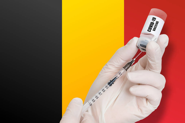 Vacunación en Bélgica. Vacuna para proteger contra el Covid-19 en el fondo de la bandera nacional. - Foto, Imagen