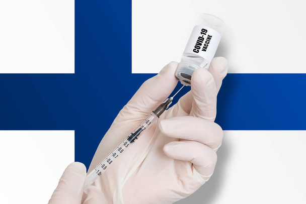 Vaccinazione in Finlandia. Vaccino per la protezione contro la Covid-19 sullo sfondo della bandiera nazionale. - Foto, immagini