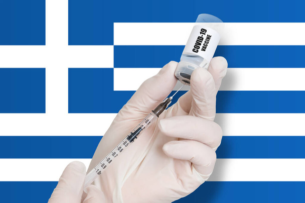 Yunanistan 'da aşı. Ulusal bayrağın arka planında Covid-19 'a karşı koruma aşısı. - Fotoğraf, Görsel