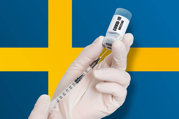 Vaccinazione in Svezia. Vaccino per la protezione contro la Covid-19 sullo sfondo della bandiera nazionale. - Foto, immagini