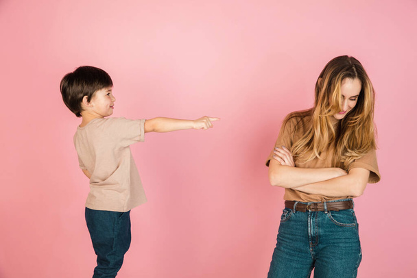 Young woman and little boy, mother and son isolated over pink background. - Photo, Image