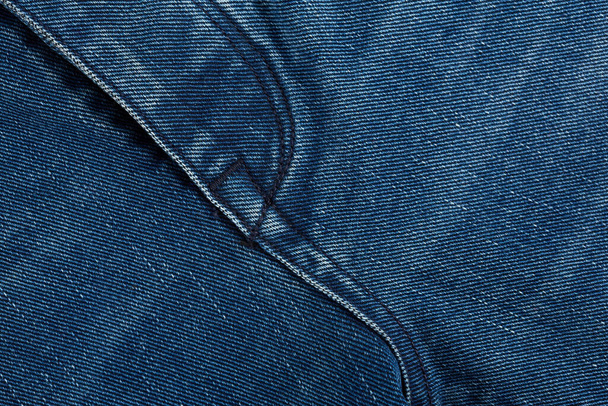 Denim jeans textuur achtergrond met gescheurd. De textuur van de gekleurde katoenen stof. Stitched textuur jeans achtergrond. Mode jeans knoop. Zak en klinknagel op jeans. Vezel- en weefselstructuur. - Foto, afbeelding