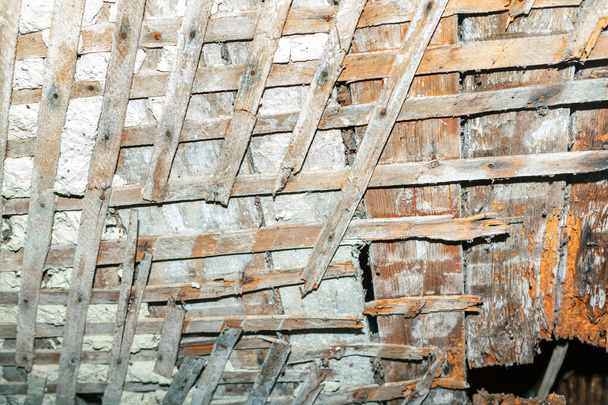 Ceiling wooden planks with destroyed plaster , ruined house details - Foto, imagen