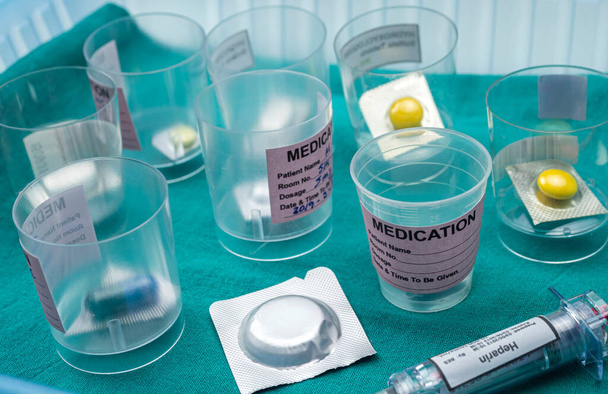 Diversos medicamentos en gafas monodosis junto con inyectores de heparina en el hospital, imagen conceptual - Foto, imagen