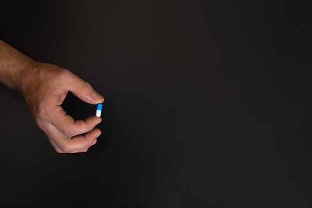 pill in the hand of a man. empty space,  - Photo, Image