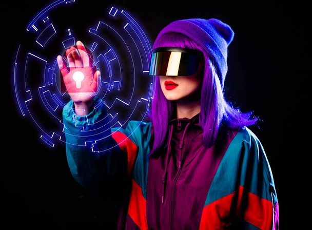 Stijlvol meisje in cyber punk bril en 80s trainingspak met 3D veilig op donkere achtergrond - Foto, afbeelding